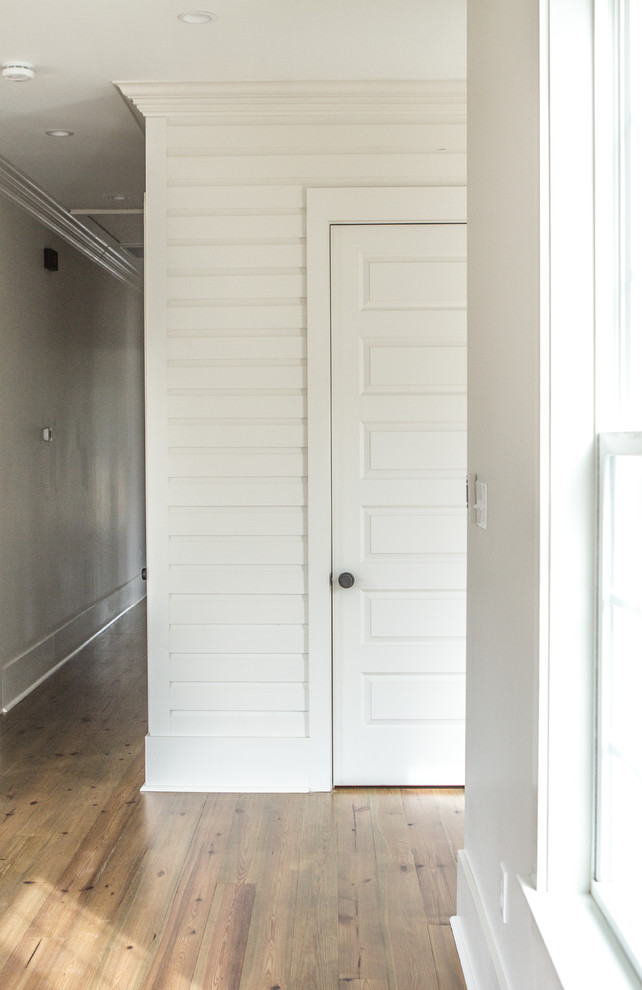 Mittelgroßer Landhaus Flur mit weißer Wandfarbe, braunem Holzboden und grauem Boden in New Orleans