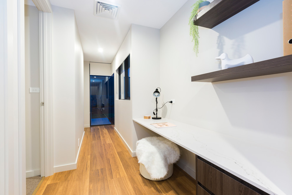 Idée de décoration pour un petit couloir design avec un mur blanc, parquet clair et un sol orange.