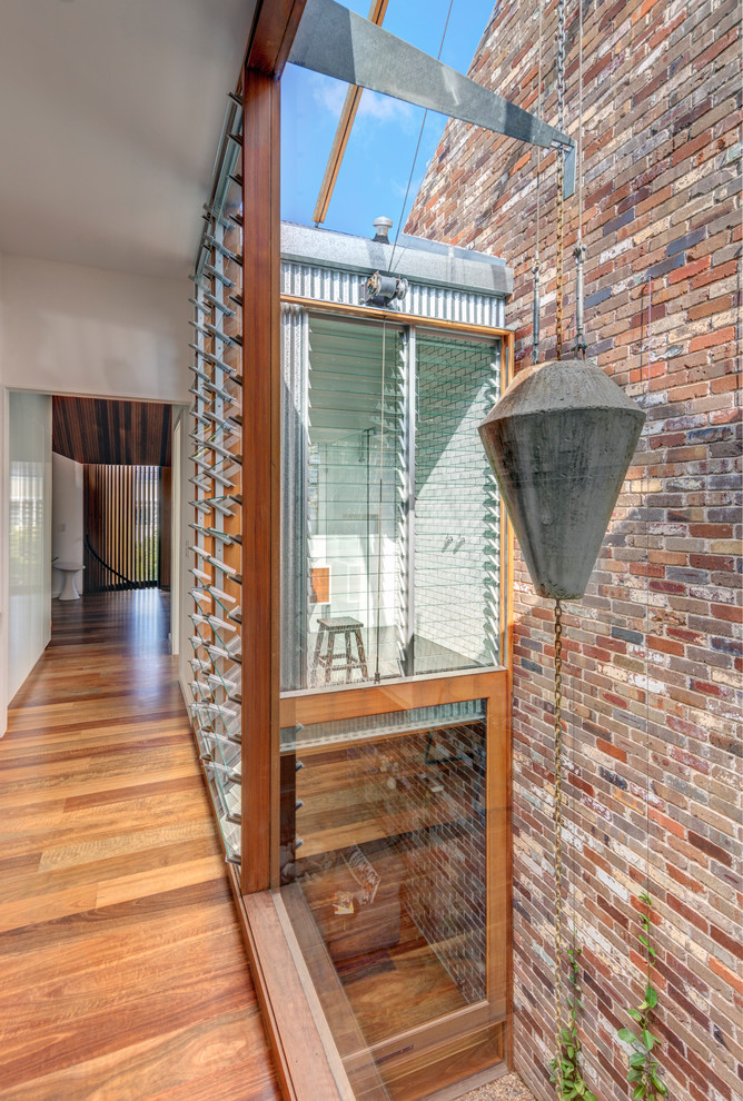 Hallway - small contemporary medium tone wood floor hallway idea in Sydney with white walls