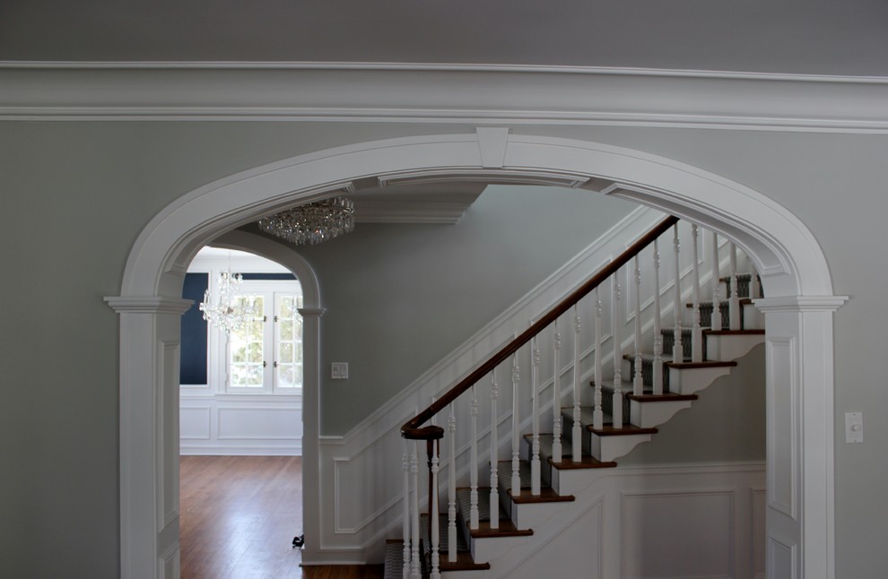 Пример оригинального дизайна: коридор среднего размера в классическом стиле с серыми стенами, темным паркетным полом, коричневым полом и панелями на стенах