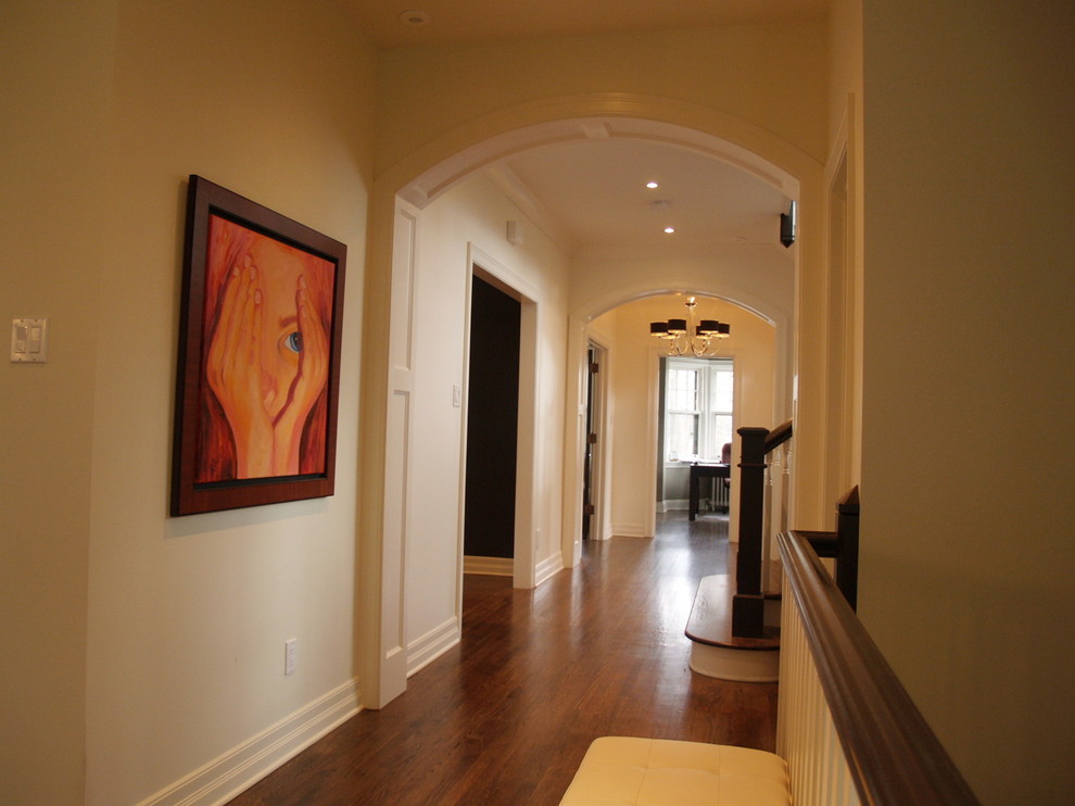 Cette image montre un couloir traditionnel de taille moyenne avec un mur beige et un sol en bois brun.