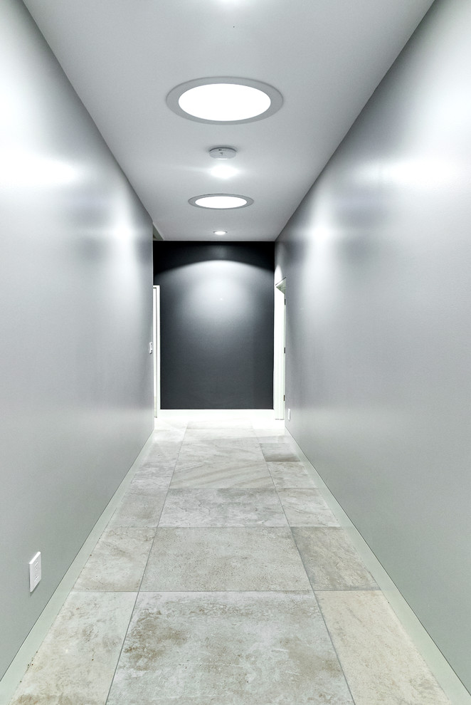 Réalisation d'un couloir design de taille moyenne avec un mur gris, un sol en carrelage de porcelaine et un sol gris.