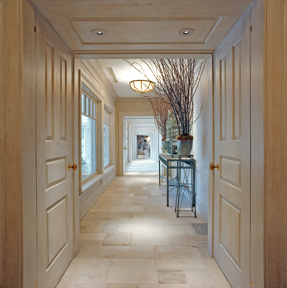 Example of a huge classic limestone floor hallway design in New York with beige walls