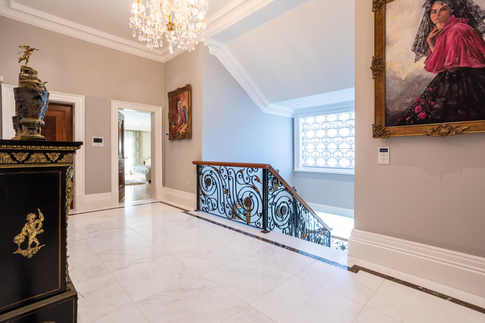 Стильный дизайн: большой коридор в современном стиле с серыми стенами, мраморным полом и белым полом - последний тренд