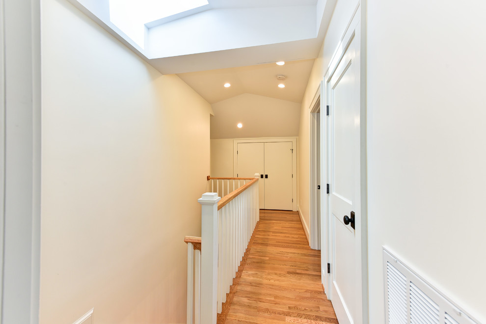 Ispirazione per un ingresso o corridoio stile americano di medie dimensioni con pareti beige e pavimento in legno massello medio