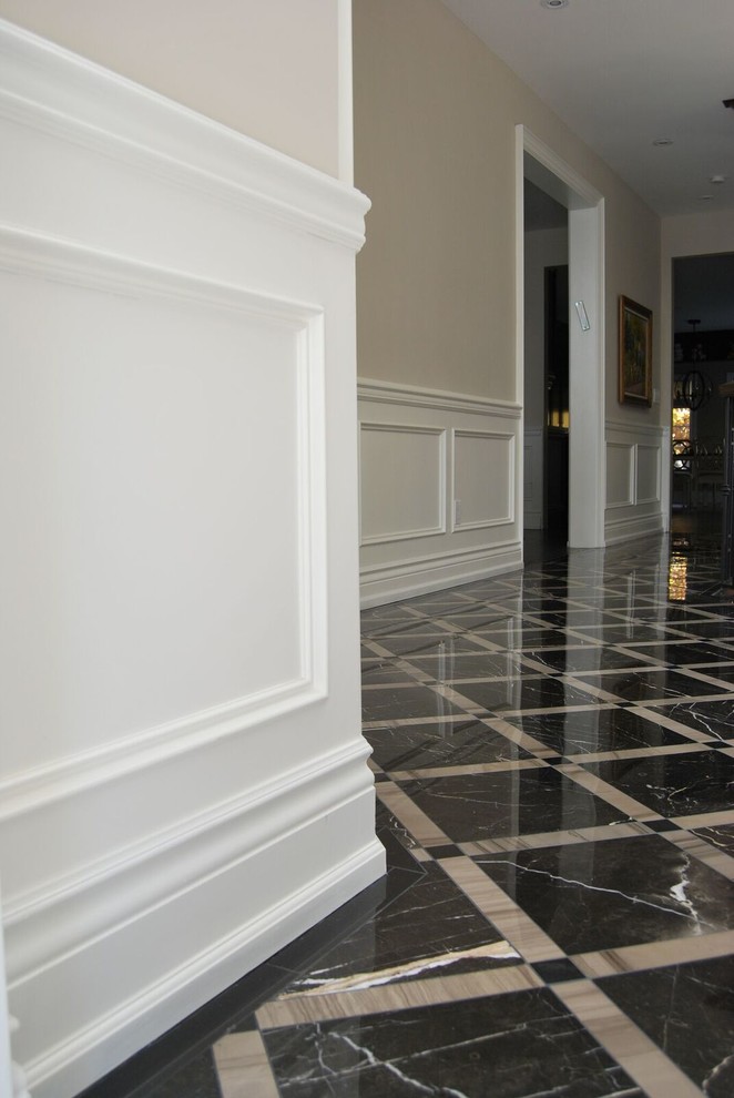 Cette image montre un couloir traditionnel avec un mur beige, un sol en marbre et un sol noir.