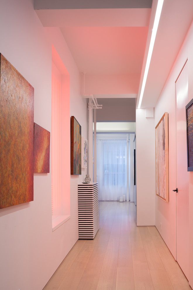 Ispirazione per un ingresso o corridoio design di medie dimensioni con pareti bianche, parquet chiaro e pavimento beige