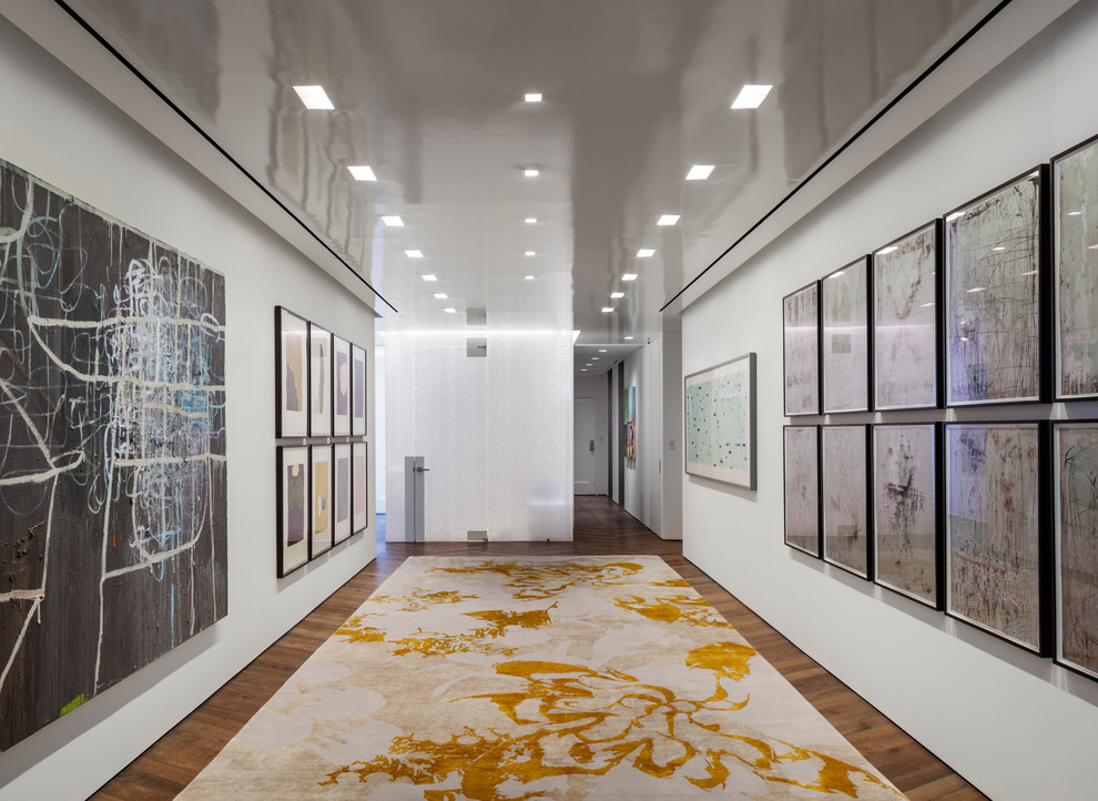 Immagine di un grande ingresso o corridoio minimal con pareti bianche e pavimento in legno massello medio