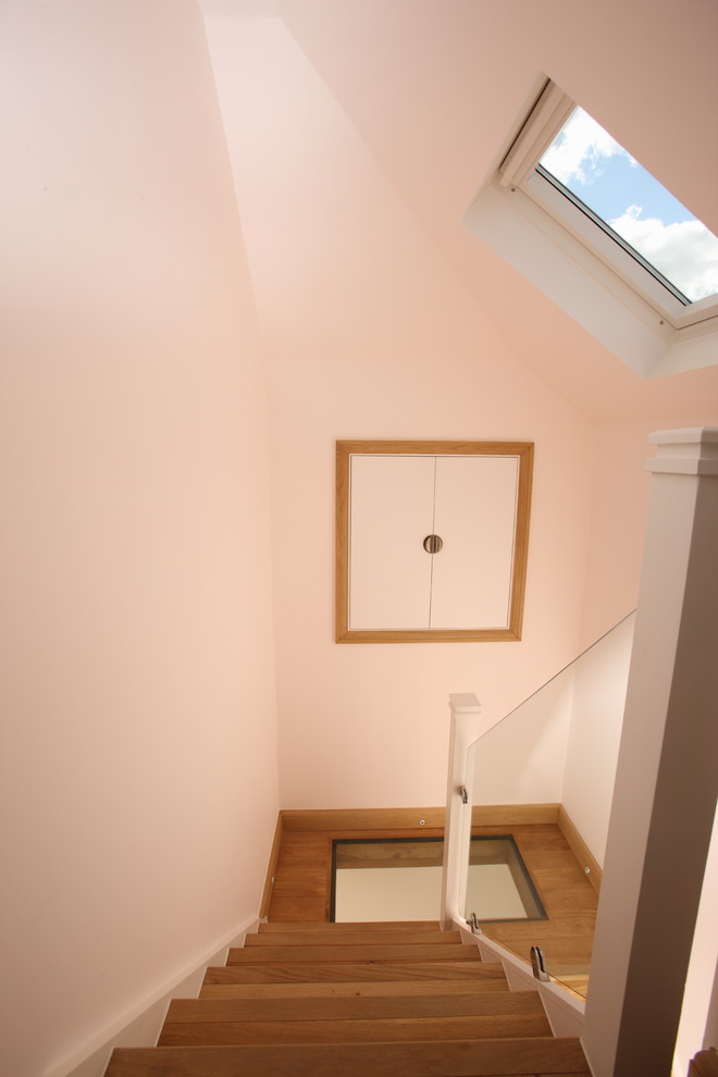 Hallway - mid-sized modern medium tone wood floor and brown floor hallway idea in London with pink walls