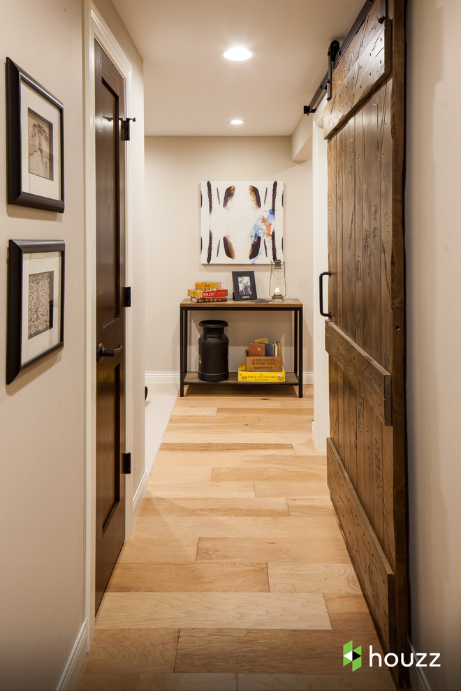 Réalisation d'un couloir chalet avec un mur beige et un sol en bois brun.