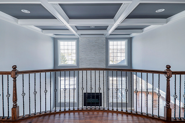 Стильный дизайн: большой коридор в стиле неоклассика (современная классика) с серыми стенами, темным паркетным полом и коричневым полом - последний тренд