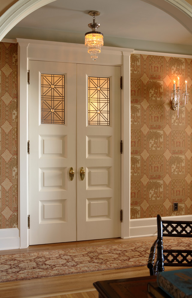Idée de décoration pour un couloir tradition avec un mur beige et un sol en bois brun.