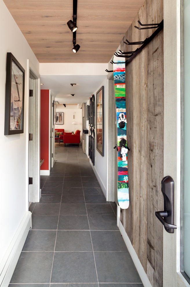 デンバーにある小さなミッドセンチュリースタイルのおしゃれな廊下 (スレートの床、白い壁) の写真