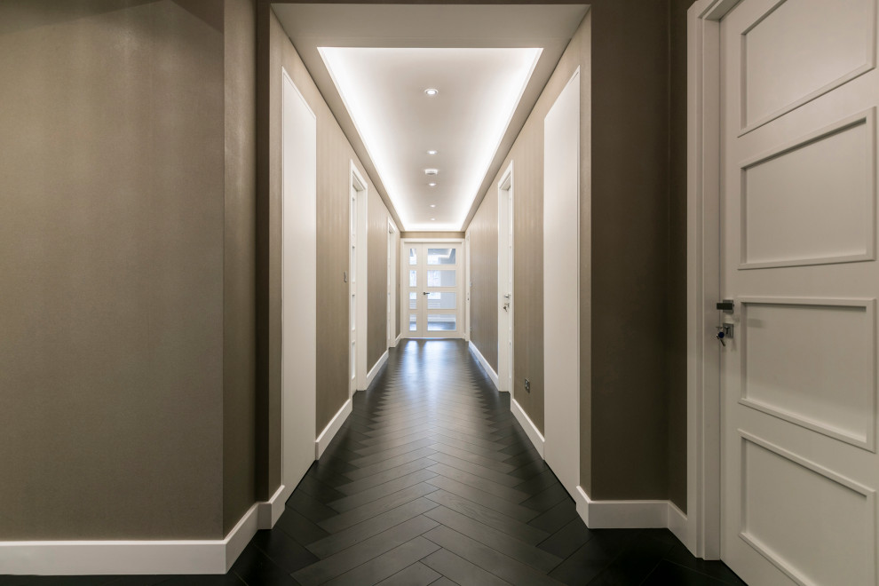 Стильный дизайн: большой коридор в современном стиле с бежевыми стенами, темным паркетным полом, коричневым полом, кессонным потолком и обоями на стенах - последний тренд