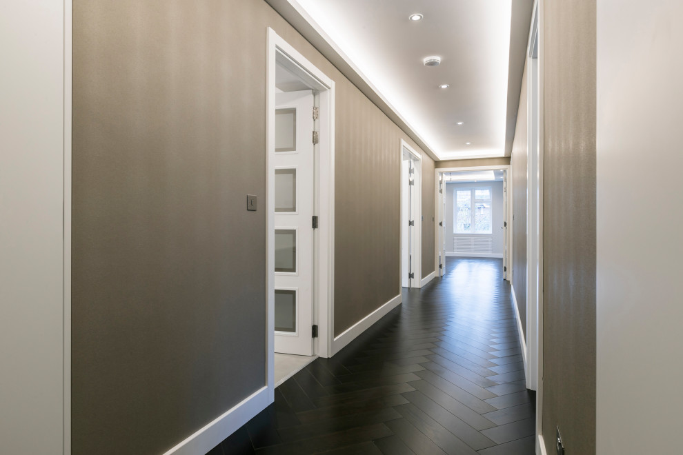 Réalisation d'un grand couloir design avec un mur beige, parquet foncé, un sol marron, un plafond à caissons et du papier peint.