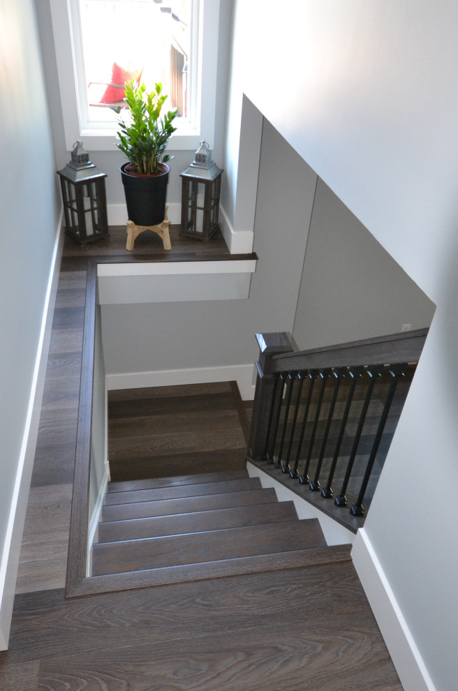 На фото: большой коридор в стиле неоклассика (современная классика) с серыми стенами, паркетным полом среднего тона и коричневым полом
