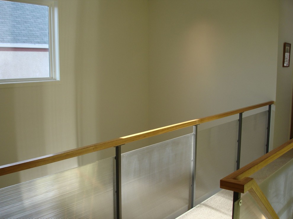 Cette image montre un couloir minimaliste avec un mur blanc et moquette.