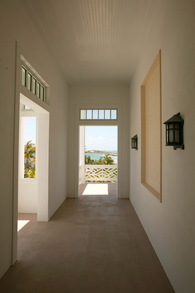 Esempio di un ingresso o corridoio tropicale di medie dimensioni con pareti bianche e pavimento in cemento