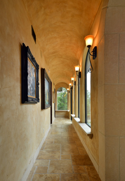 Large tuscan travertine floor hallway photo in Austin with brown walls