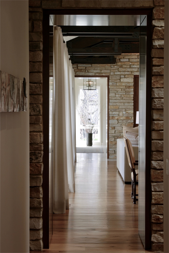 Ispirazione per un ingresso o corridoio tradizionale con pareti beige, parquet chiaro, pavimento marrone e pareti in mattoni
