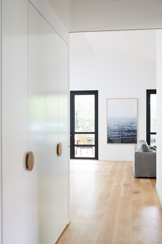 Imagen de recibidores y pasillos nórdicos grandes con paredes blancas y suelo de madera clara