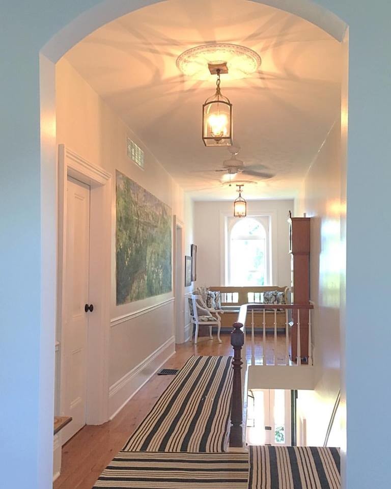 Ejemplo de recibidores y pasillos tradicionales renovados con paredes blancas y suelo de madera en tonos medios