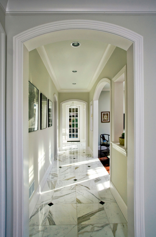 Cette photo montre un couloir chic de taille moyenne avec un mur vert, un sol en marbre et un sol blanc.