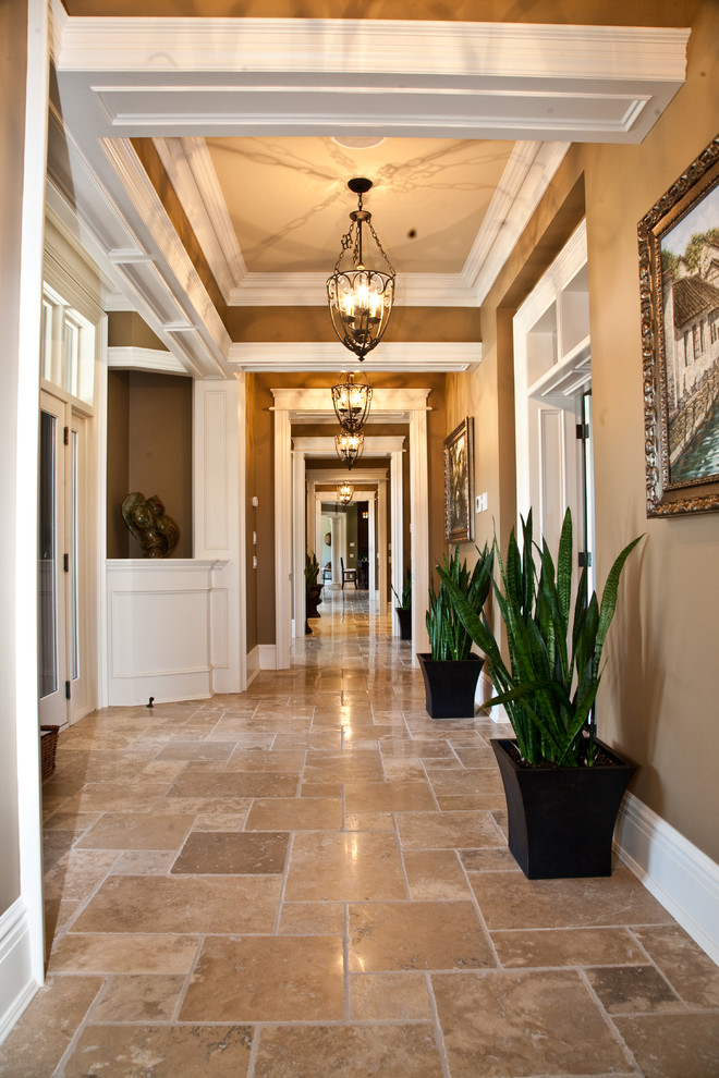 Inspiration pour un grand couloir traditionnel avec un mur marron, un sol en travertin et un sol marron.