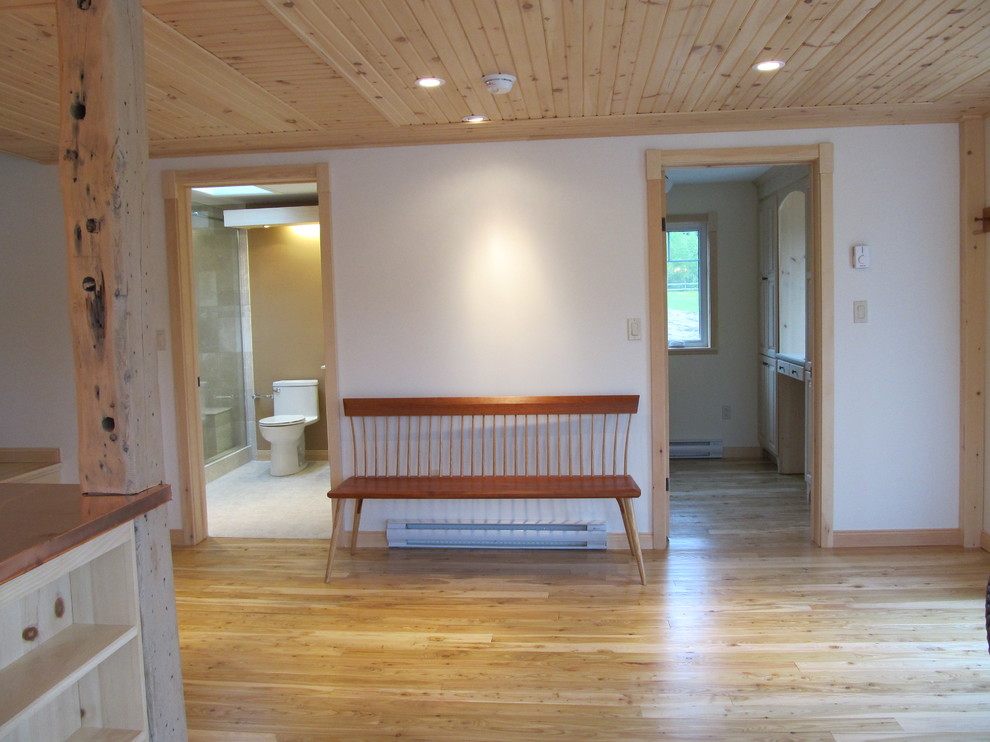 Bild på en liten rustik hall, med vita väggar, ljust trägolv och beiget golv