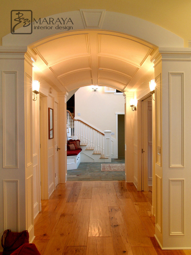 Réalisation d'un grand couloir tradition avec un mur blanc et parquet clair.