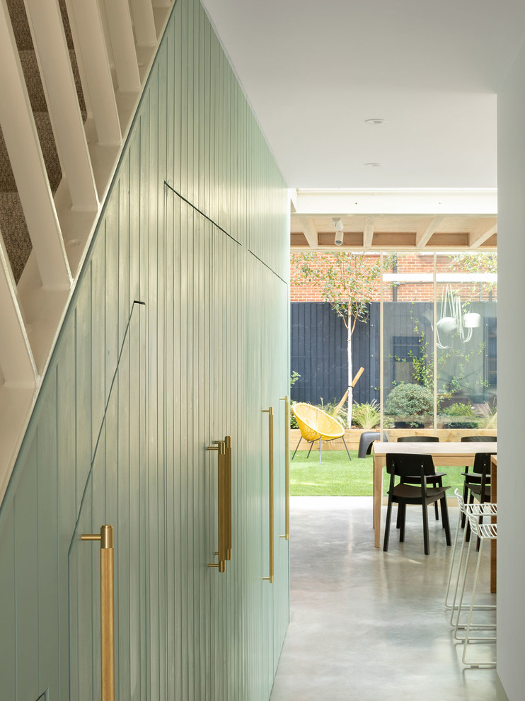 Стильный дизайн: большой коридор в стиле модернизм с разноцветными стенами, бетонным полом и серым полом - последний тренд