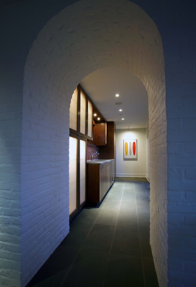 На фото: коридор среднего размера в стиле модернизм с белыми стенами, полом из сланца и серым полом