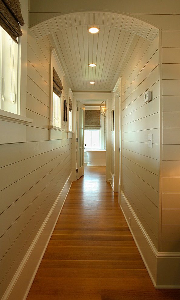 Immagine di un ingresso o corridoio tropicale di medie dimensioni con pareti beige e pavimento in legno massello medio