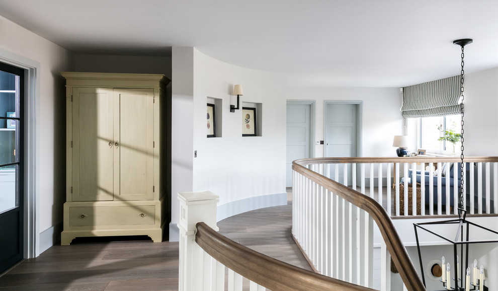 Ispirazione per un ingresso o corridoio stile marinaro con pareti bianche, pavimento in legno massello medio e pavimento marrone
