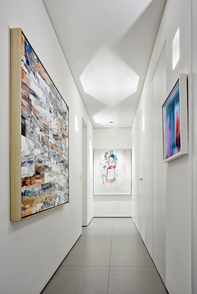 На фото: коридор среднего размера в стиле модернизм с белыми стенами и серым полом