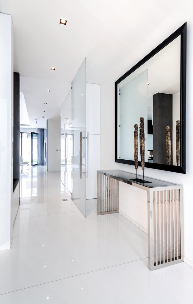 Immagine di un ingresso o corridoio minimalista di medie dimensioni con pareti bianche e pavimento bianco