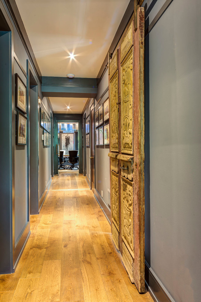 Inspiration för stora klassiska hallar, med blå väggar, ljust trägolv och brunt golv