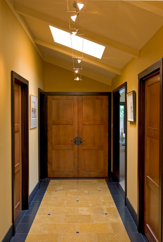 На фото: коридор среднего размера в современном стиле с желтыми стенами и полом из известняка с