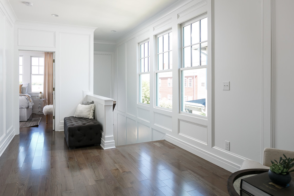 Example of a mid-sized transitional medium tone wood floor hallway design in Louisville with white walls