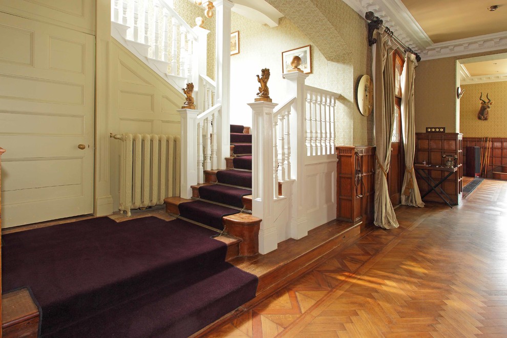Esempio di un ampio ingresso o corridoio chic con pareti viola e moquette