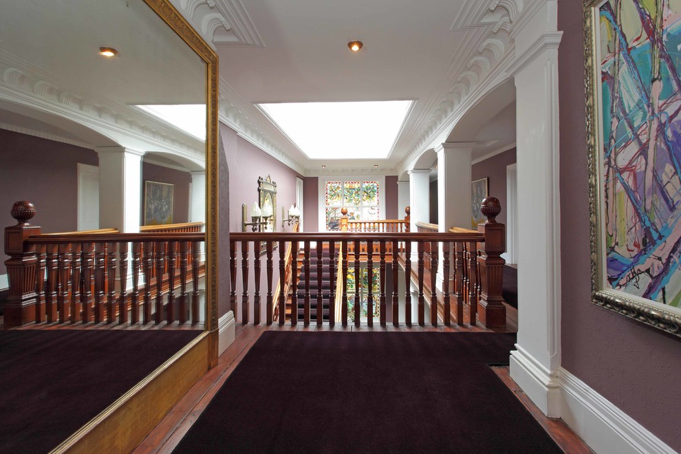 Immagine di un ampio ingresso o corridoio classico con pareti viola e moquette