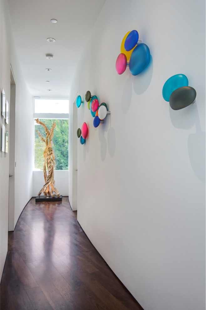 Example of a large trendy medium tone wood floor hallway design in Los Angeles with white walls