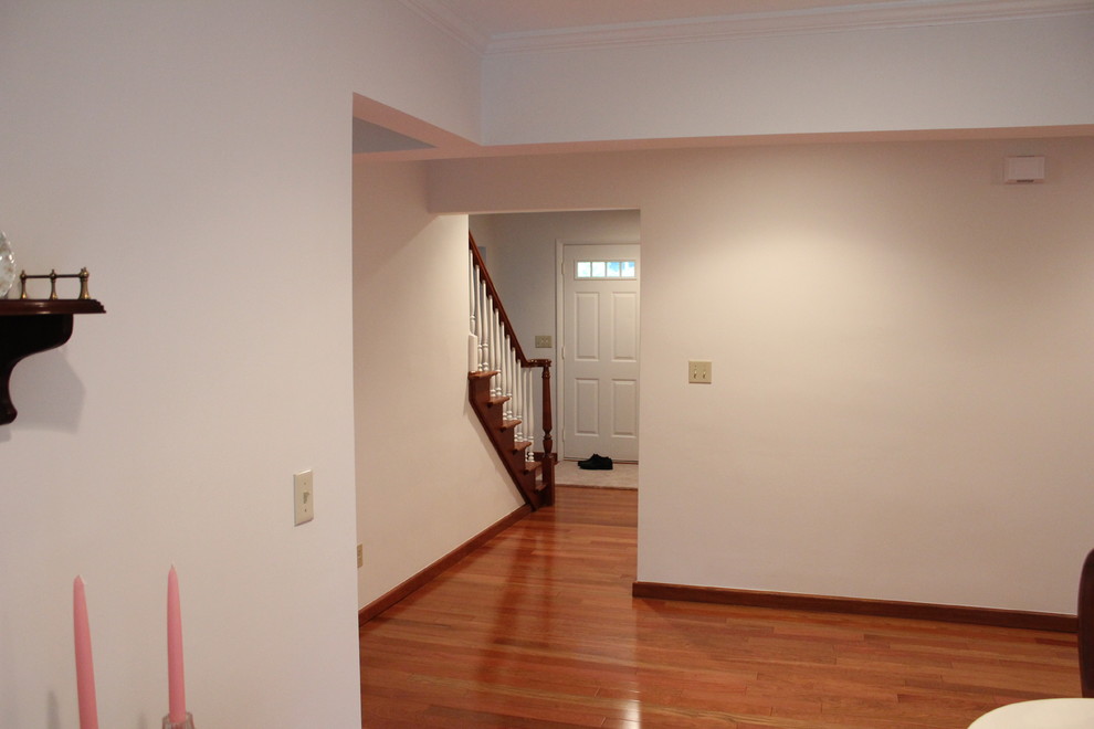 Hallway - mid-sized traditional medium tone wood floor hallway idea in Detroit with white walls