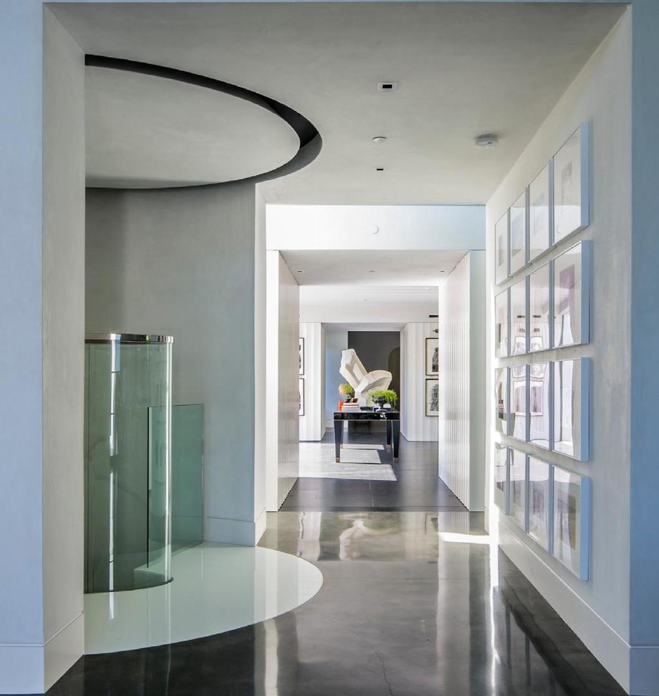 Пример оригинального дизайна: огромный коридор в стиле неоклассика (современная классика) с белыми стенами и бетонным полом