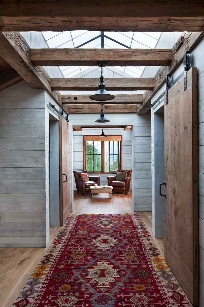 Foto de recibidores y pasillos rústicos de tamaño medio con paredes grises y suelo de madera clara