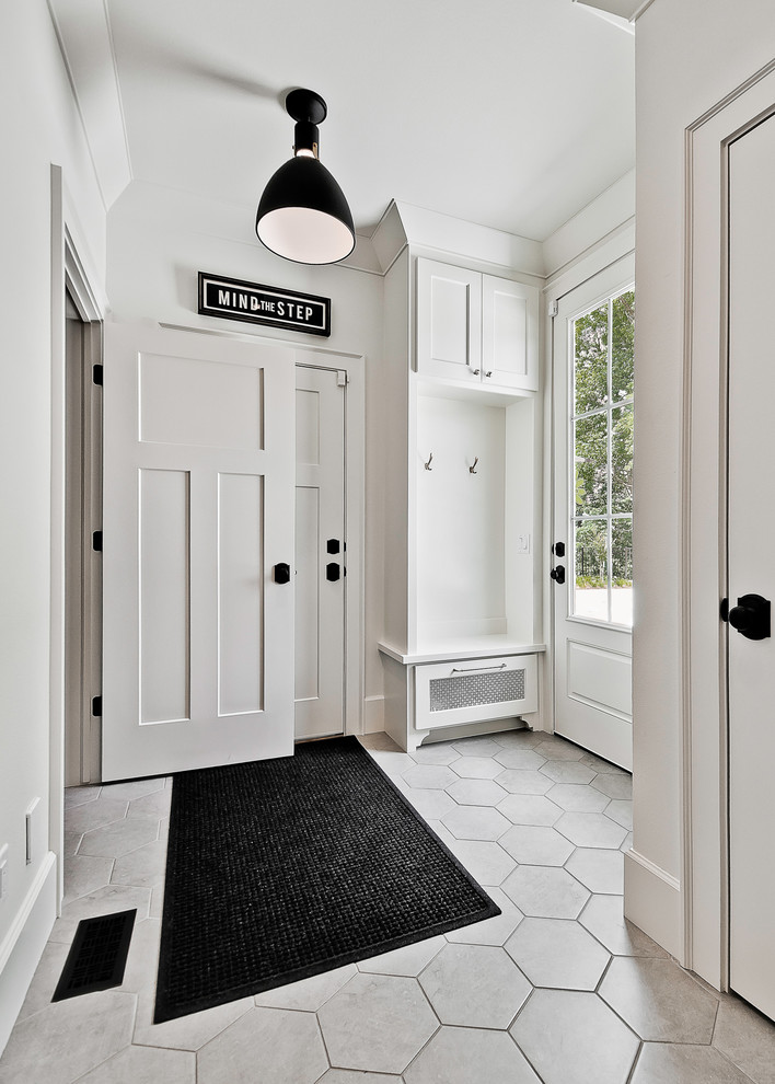 Ejemplo de recibidores y pasillos de estilo americano pequeños con paredes blancas y suelo de baldosas de cerámica