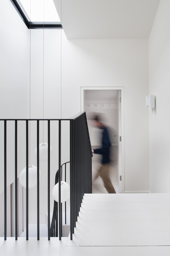 На фото: коридор среднего размера в стиле неоклассика (современная классика) с белыми стенами, деревянным полом и белым полом с