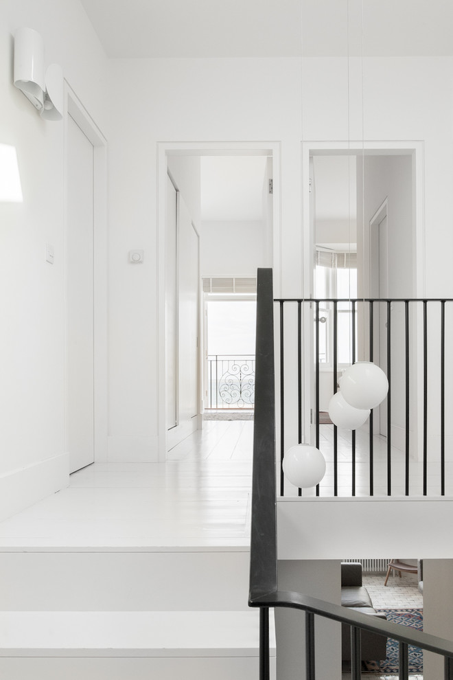 Идея дизайна: коридор среднего размера в стиле неоклассика (современная классика) с белыми стенами, деревянным полом и белым полом