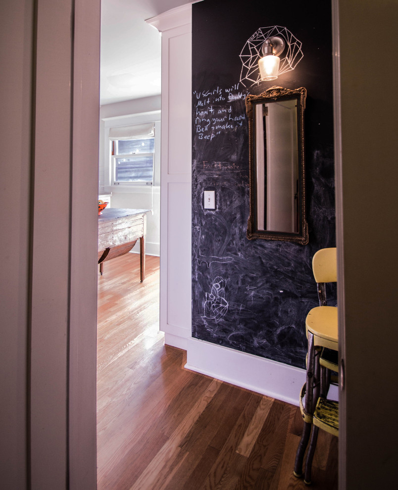 Aménagement d'un petit couloir éclectique avec un mur blanc et un sol en bois brun.
