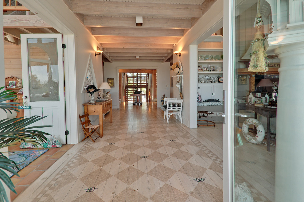 Immagine di un ampio ingresso o corridoio stile marino con pavimento in legno verniciato e pareti bianche